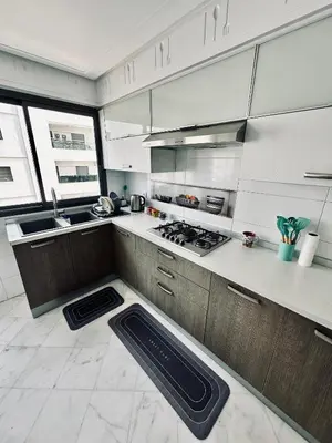 a kitchen with white cabinets and a stove top oven at Cozy apart in the heart of fez in Fès