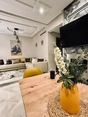 a living room with a table with a vase of flowers at Cozy apart in the heart of fez in Fès