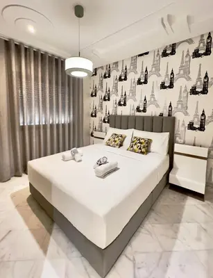 a bedroom with a large white bed and a wall with wine bottles at Cozy apart in the heart of fez in Fès