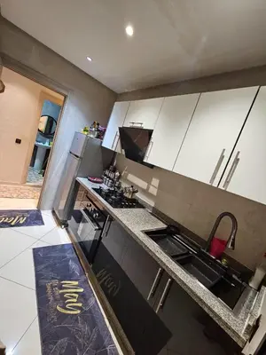 a kitchen with white cabinets and a counter top at Hay mabroka in Oulad Akkou