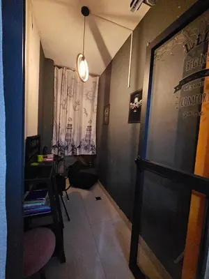 a hallway with a chair and a table and a window at Hay mabroka in Oulad Akkou