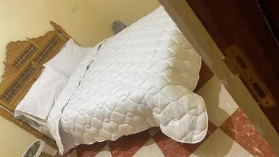 a bed with white sheets and pillows on it at Residence meknes in Meknès