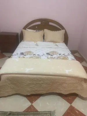 a bed with a wooden headboard in a room at Residence meknes in Meknès