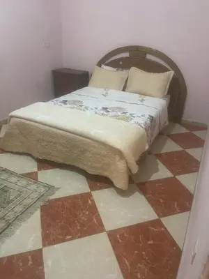 a bedroom with a bed on a checkered floor at Residence meknes in Meknès