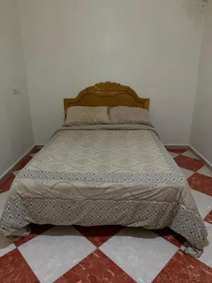 a bed sitting in a bedroom with a tiled floor at Residence meknes in Meknès