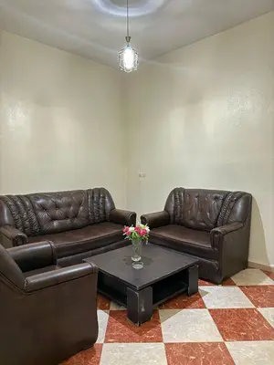 a living room with two leather couches and a coffee table at Residence meknes in Meknès