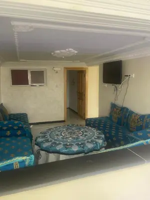 a room with a bed and a couch and a tv at منزل العمراني in Oulad Akkou