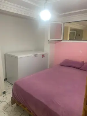 a bedroom with a purple bed and a white cabinet at منزل العمراني in Oulad Akkou