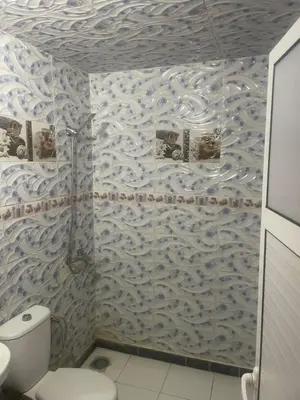 a bathroom with a white toilet in a room at منزل العمراني in Oulad Akkou