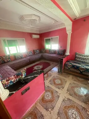 a large living room with red walls and couches at منزل العمراني in Oulad Akkou