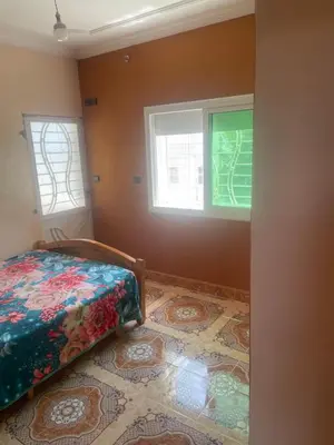a bedroom with a bed and two windows at منزل العمراني in Oulad Akkou