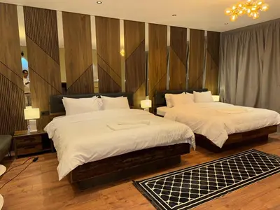 two beds in a hotel room with two lamps at Suite Bahiya 21 in Fès