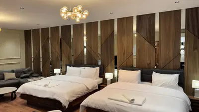a hotel room with two beds and a chandelier at Suite Bahiya 21 in Fès