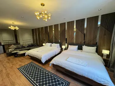 a hotel room with two beds and a chandelier at Suite Bahiya 21 in Fès