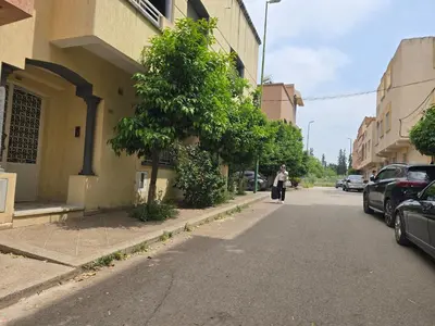 a person walking down a street next to a building at Appartement familial شقة للعائلة in Meknès