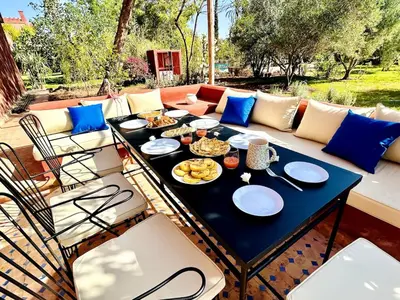 a table with plates of food on a patio at Villa Dar Ambre in Marrakech