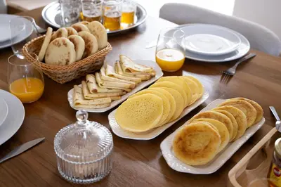 a wooden table topped with plates of bread and pastries at Villa Dar Ambre in Marrakech