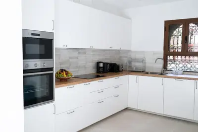 a white kitchen with white cabinets and appliances at Villa Dar Ambre in Marrakech