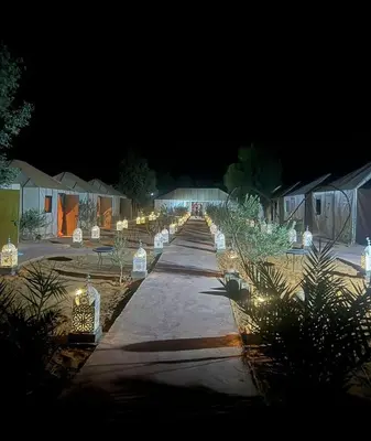 a long pathway with lights at night at Merzouga in Oulad Akkou
