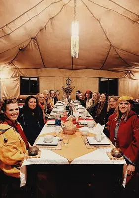 a group of women sitting around a long table at Merzouga in Oulad Akkou