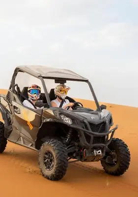 two people riding in a quad bike in the desert at Merzouga in Oulad Akkou