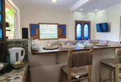 a room with a bar with chairs and a table at Charming Villa with Pool in Amekhlig