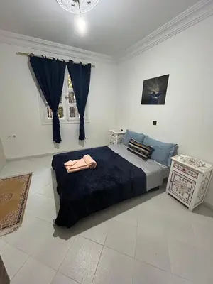 a bedroom with a large bed with a blue blanket at Agadir apartment with garden near Souk El Had in Oulad Akkou