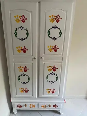 a white cabinet with floral designs on it at Agadir apartment with garden near Souk El Had in Oulad Akkou