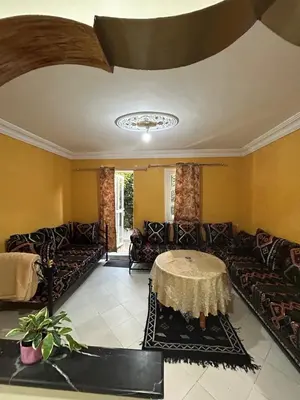 a living room with couches and a table at Agadir apartment with garden near Souk El Had in Oulad Akkou