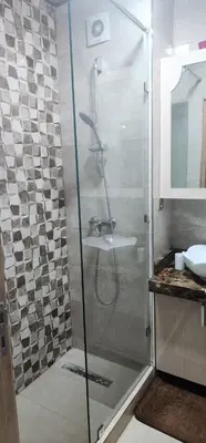 a shower with a glass door in a bathroom at مفتاح الساحل انزا in Oulad Akkou