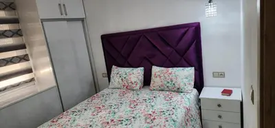 a bed with a purple headboard in a bedroom at مفتاح الساحل انزا in Oulad Akkou