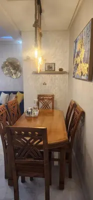 a wooden table and chairs in a room at مفتاح الساحل انزا in Oulad Akkou