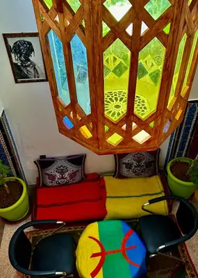 a room with a table and chairs with a window at Raid rooftop atlas dades in Boumalne