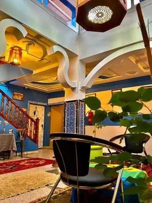 a living room with a table and a plant at Raid rooftop atlas dades in Boumalne