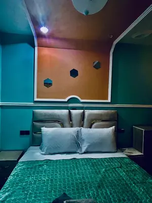 a bed in a room with a wall with a window at Raid rooftop atlas dades in Boumalne