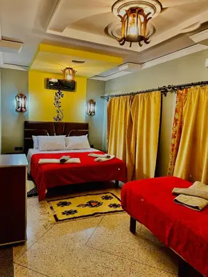 a bedroom with two beds and a chandelier at Raid rooftop atlas dades in Boumalne