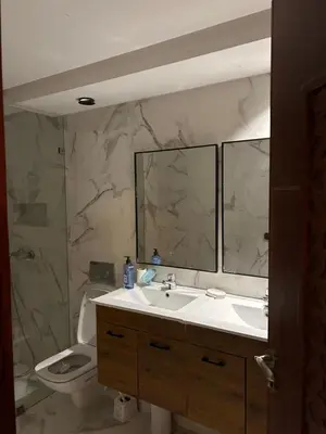 a bathroom with a sink and a toilet and a mirror at Appartement spacieux in Oulad Akkou