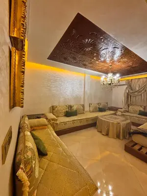 a living room with a couch and a table at Appartement spacieux in Oulad Akkou