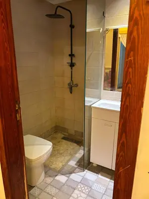 a bathroom with a shower and a toilet and a sink at Appartement spacieux in Oulad Akkou