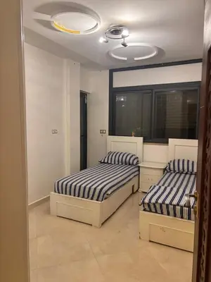 a bedroom with two beds and a ceiling at Appartement spacieux in Oulad Akkou