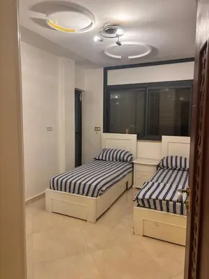 a bedroom with two beds and a ceiling at Appartement spacieux in Oulad Akkou