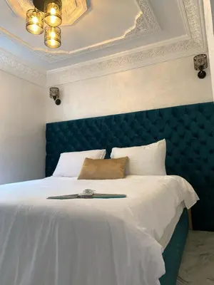 a bedroom with a large bed with a blue headboard at Appartement bel kayed in Fès
