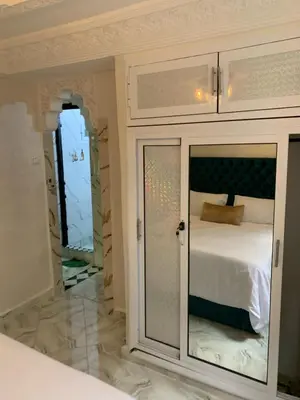 a bedroom with a bed with a glass door at Appartement bel kayed in Fès