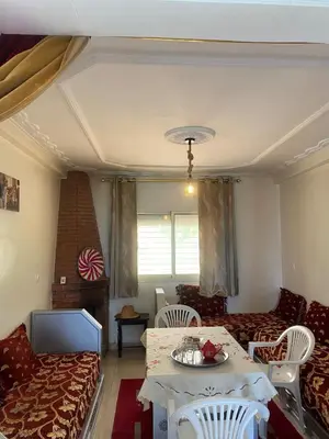 a living room with a couch and a table and chairs at Ferme Arougo in Oulad Akkou