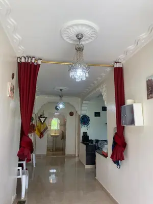 a hallway with red drapes and a living room at Ferme Arougo in Oulad Akkou