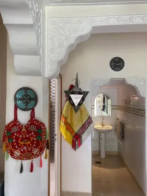 a room with a hallway with a mirror and some clothes at Ferme Arougo in Oulad Akkou