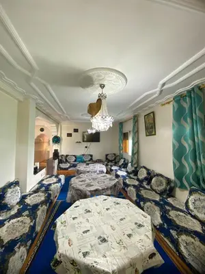 a living room with couches and a chandelier at Ferme Arougo in Oulad Akkou