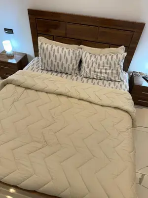 a large bed in a bedroom with two night stands at Mehdia plage apparemment in Oulad Akkou