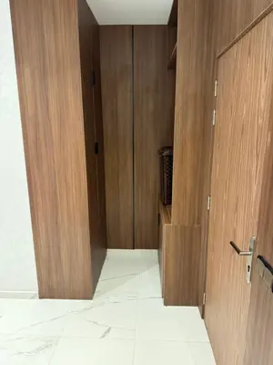 a closet with wooden doors in a room at Mehdia plage apparemment in Oulad Akkou