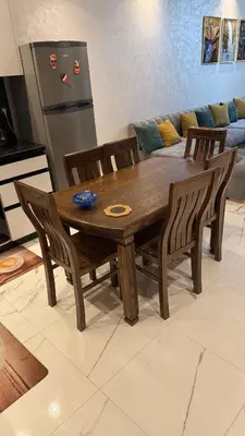 a wooden table and chairs in a kitchen at Mehdia plage apparemment in Oulad Akkou